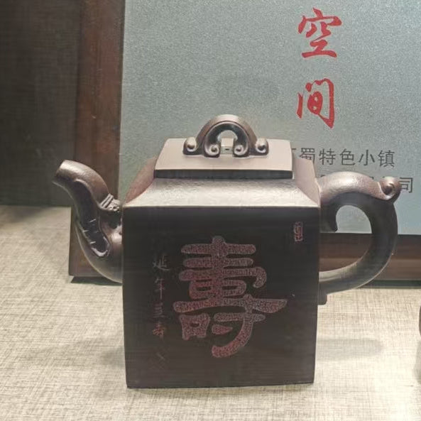 Tea set with a teapot, cup, and small container on a reflective surface.