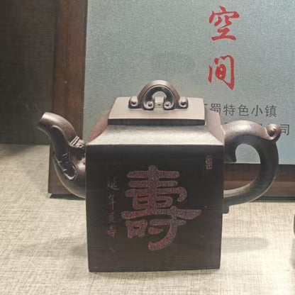 Tea set with a teapot, cup, and small container on a reflective surface.